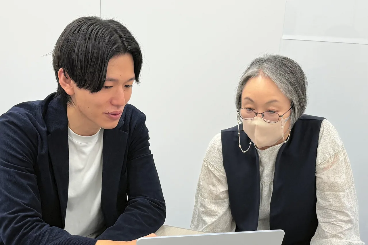杉山と渡邉様がノートパソコンを見ながら話している様子
